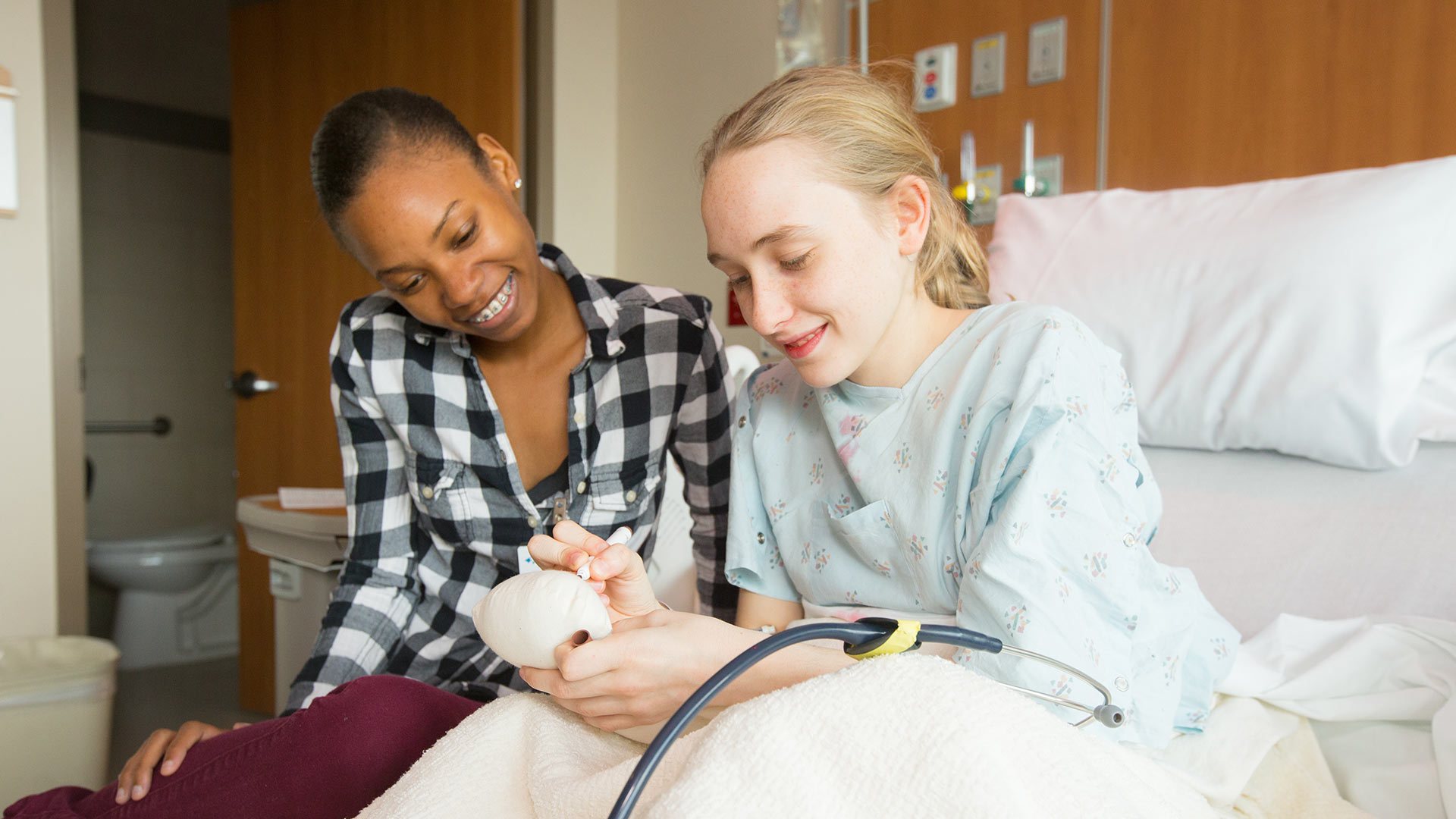Child life student interacting with hospitalized kid