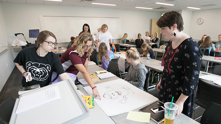 Three students doing a group drawing activity during an education class.
