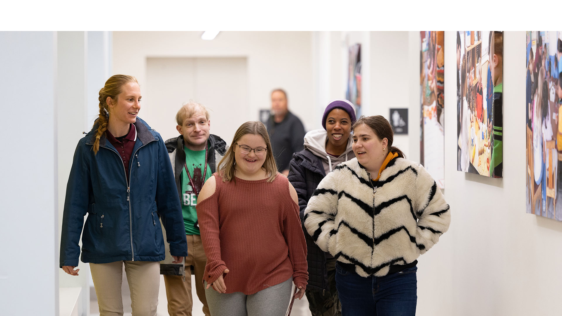 Five Bear POWER students and ambassadors stroll down a hallway.