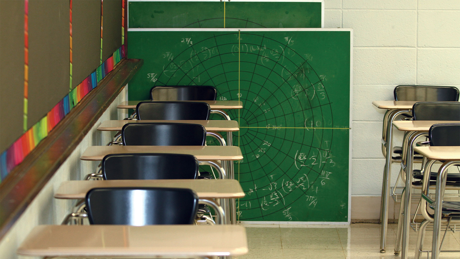 Chair-desks lined up in a classroom.