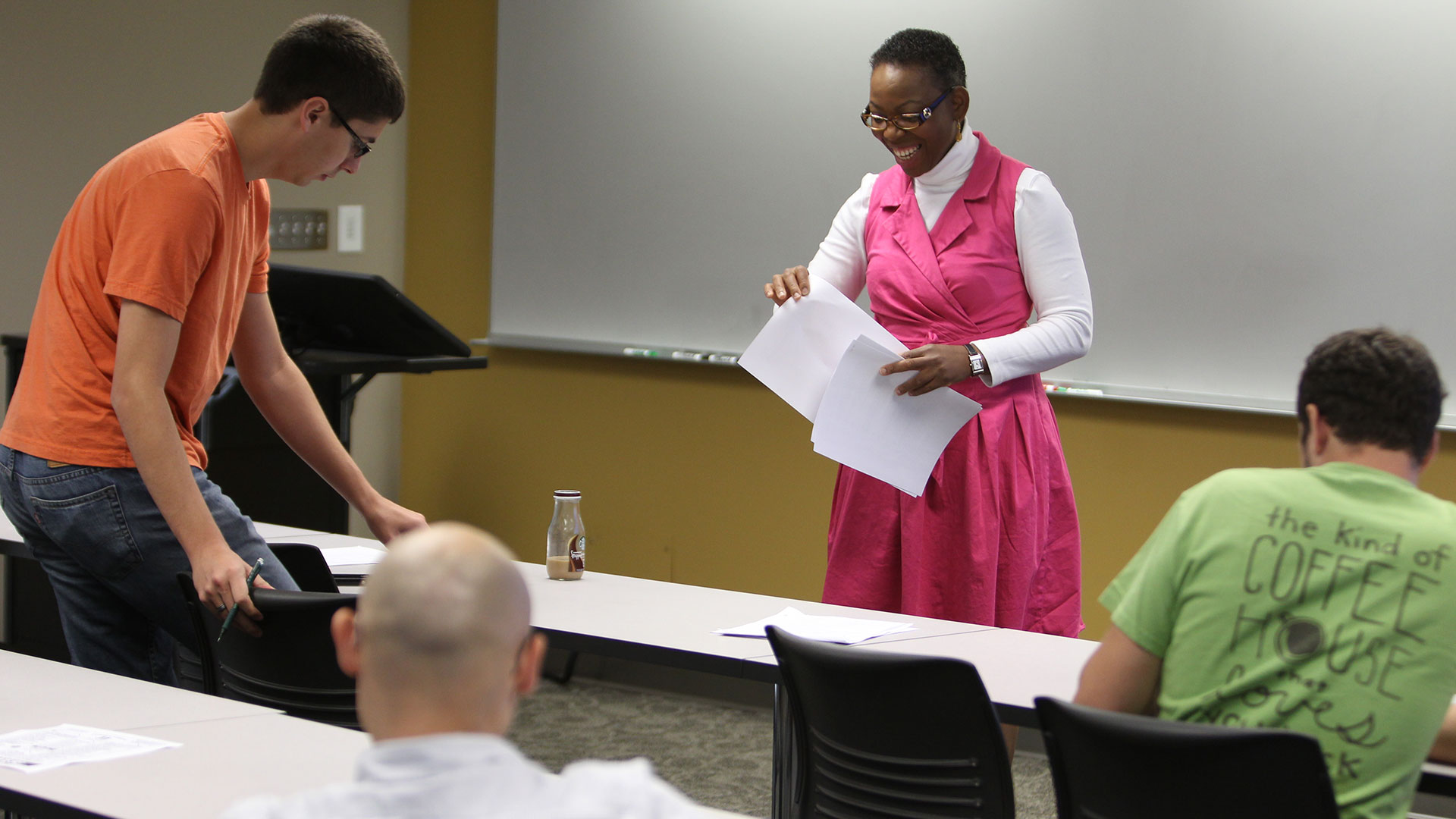 A professor distributes worksheets to students in a cooperative engineering class.