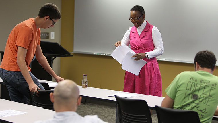 A professor distributes worksheets to students in a cooperative engineering class.