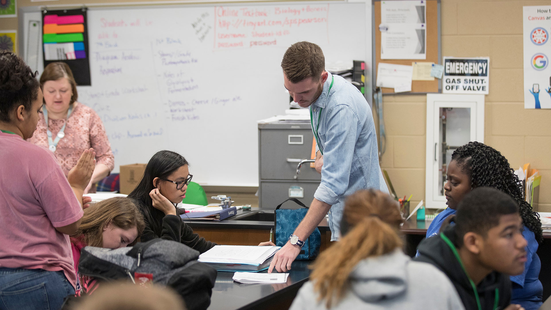 MSU student Kendell Loyd points at a problem on a student's worksheet.