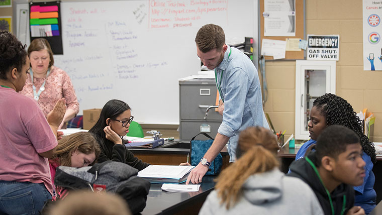 MSU student Kendell Loyd points at a problem on a student's worksheet.