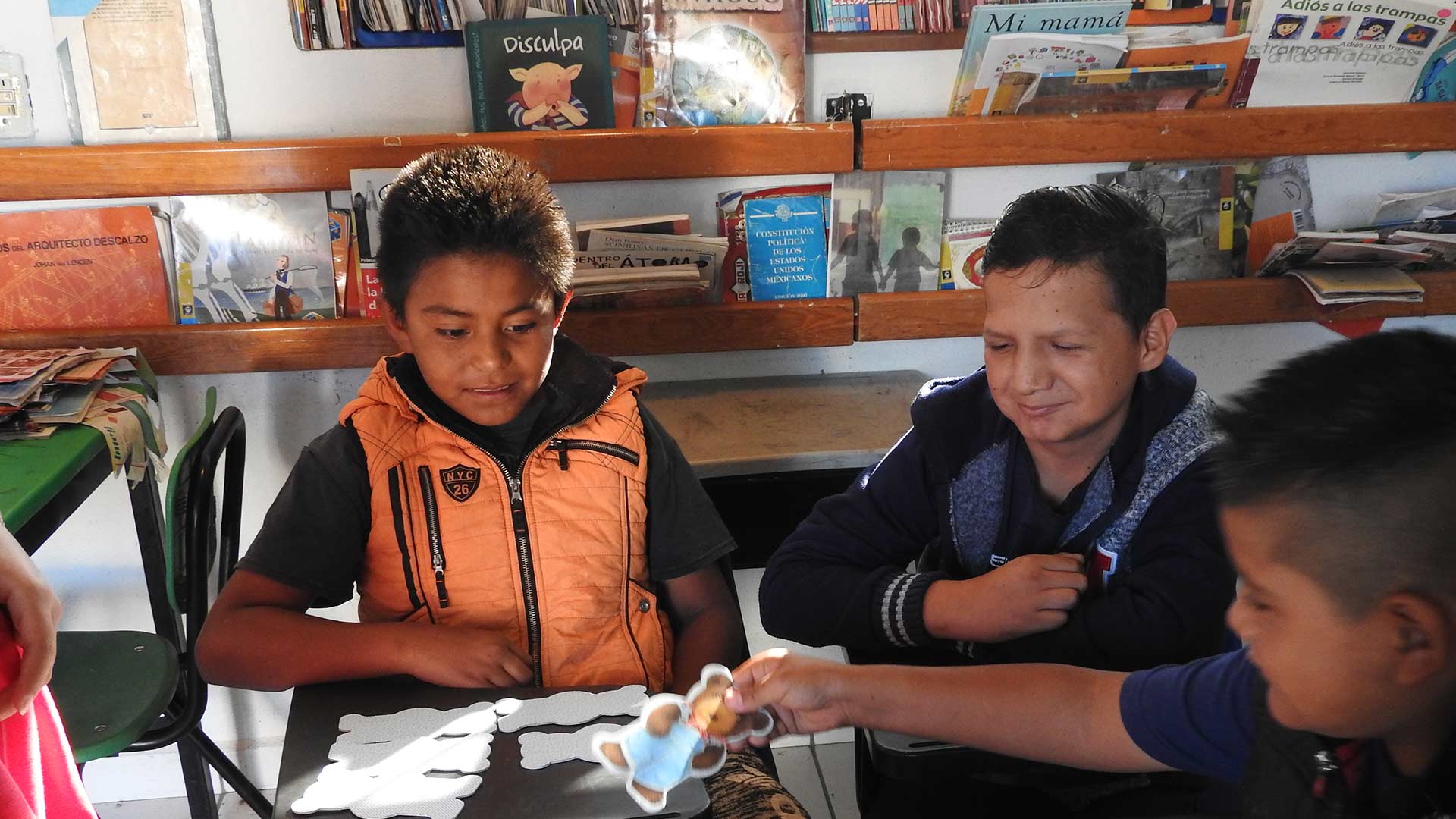 Children in a library do an activity at a table.