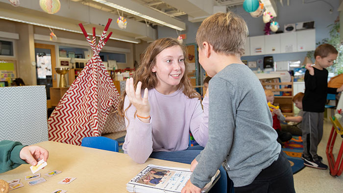 Student working one-on-one with child at daycare center