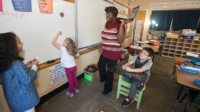 Student teacher working with elementary school students