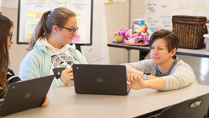 Family and consumer sciences teacher working with students in classroom.