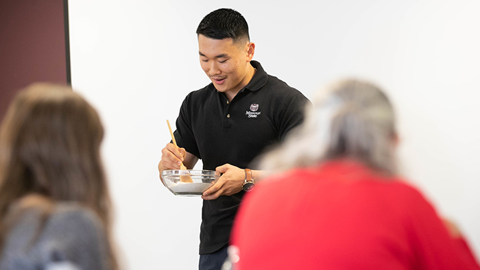 Student giving food prep demonstration