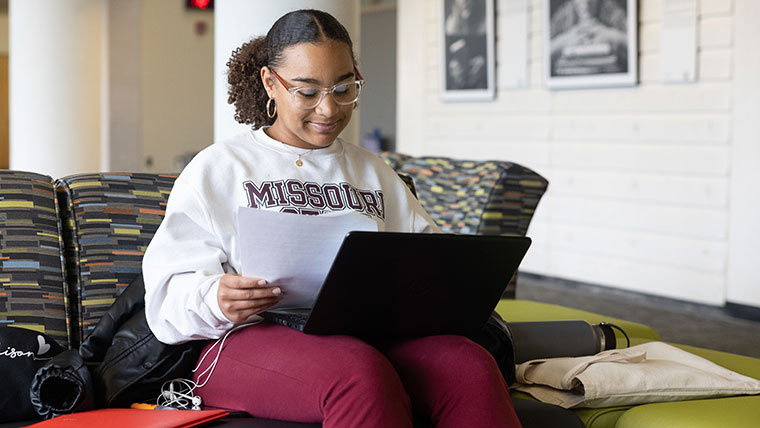 A student on her laptop studies in Meyer Library.