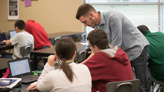 Student teacher working with students in high school classroom