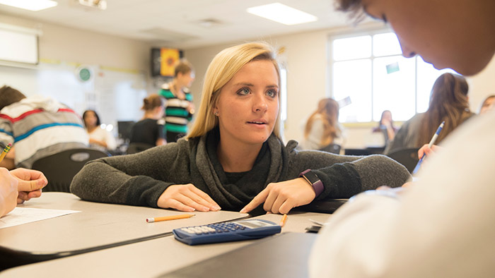 Student teacher helping high school student