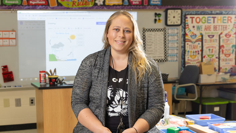 Smiling teacher sitting within her classroom