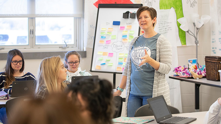 A family and consumer sciences teacher speaking to her high school students during class.