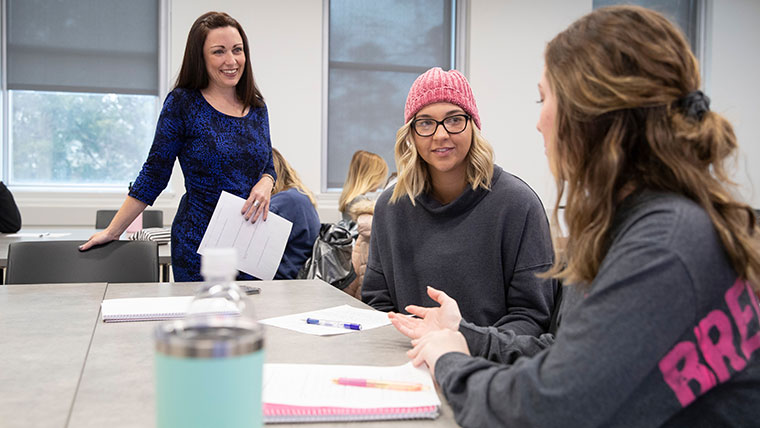 Students discussing dissertation with professor