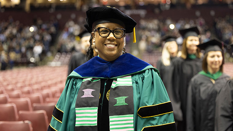 Dr. Nicole West, an associate professor in the School of Special Education, Leadership and Professional Studies, smiles during a commencement ceremony.