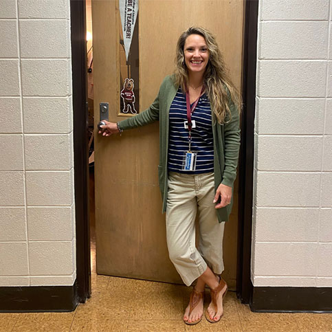 Hannah Dunville poses in front of the door to her classroom